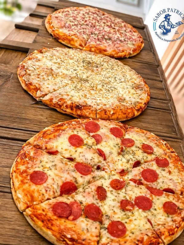 Tres pizzas argentinas sobre tabla de madera